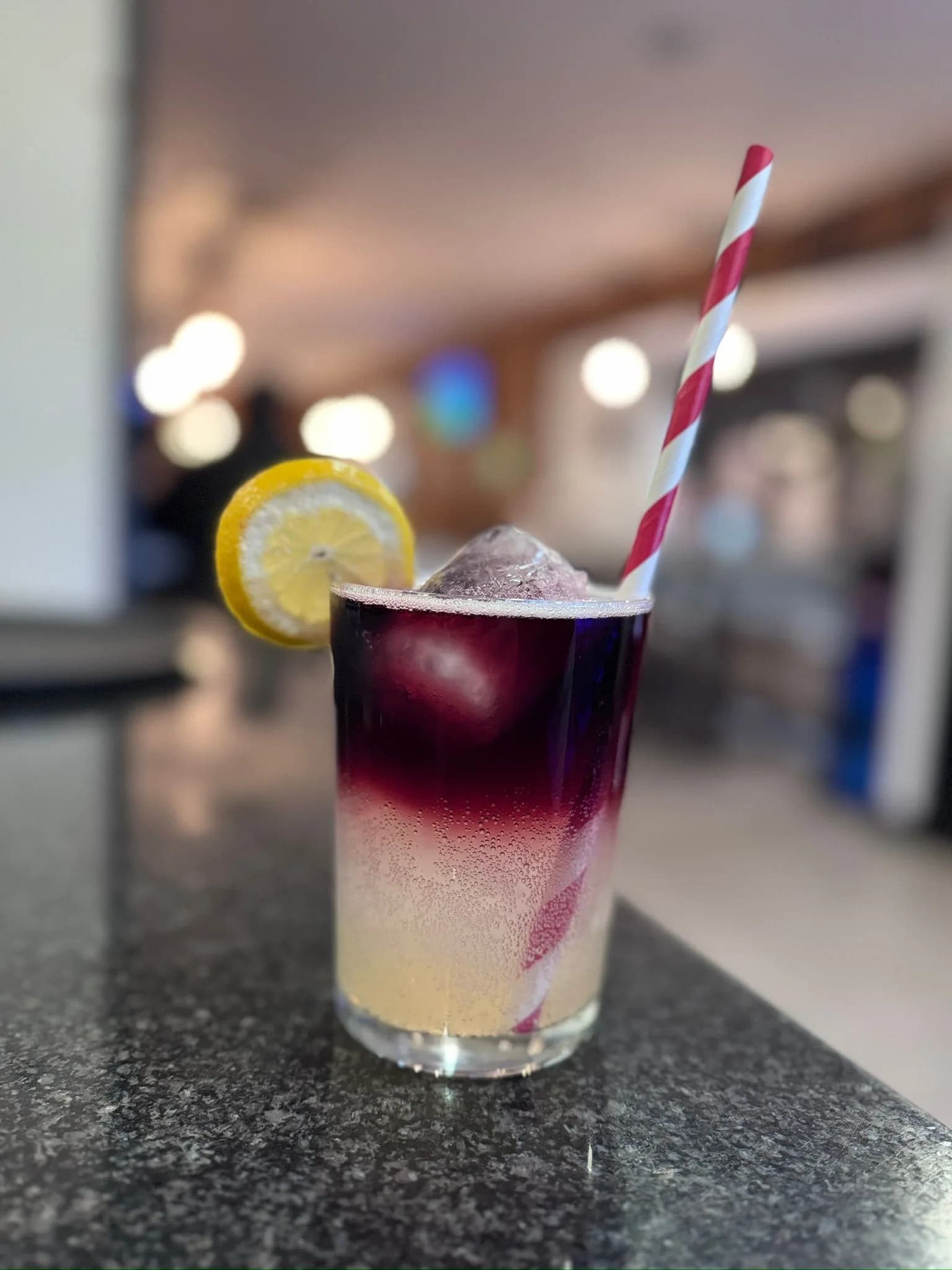 Vaso de tinto de verano con hielo y rodaja de limón sobre la barra