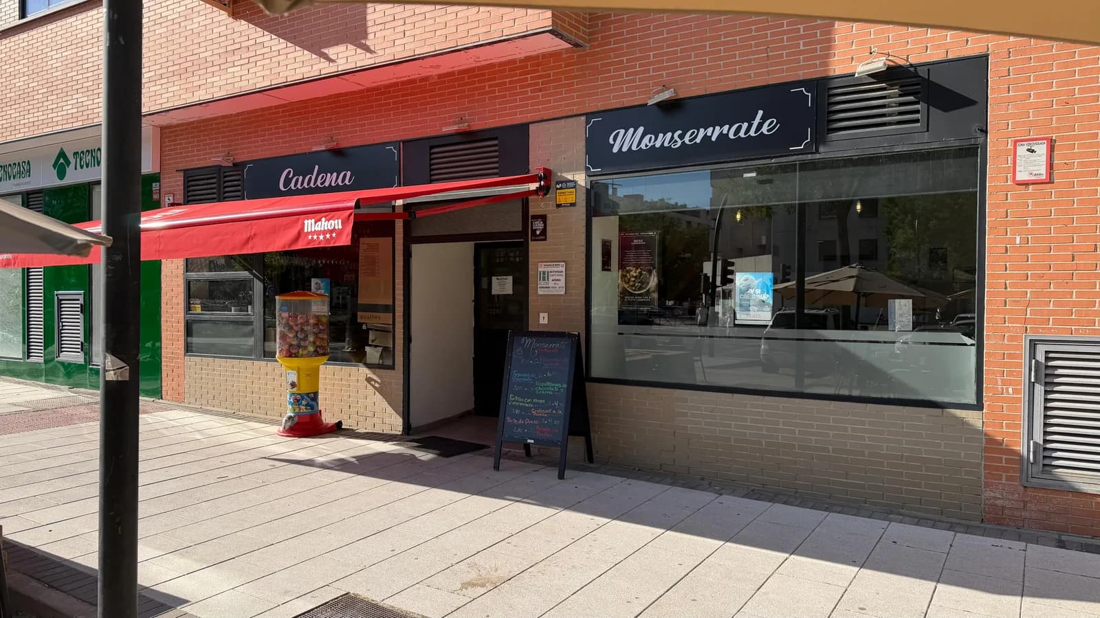 Entrada principal con los rótulos Cadena y Monserrate y la pizarra de postres